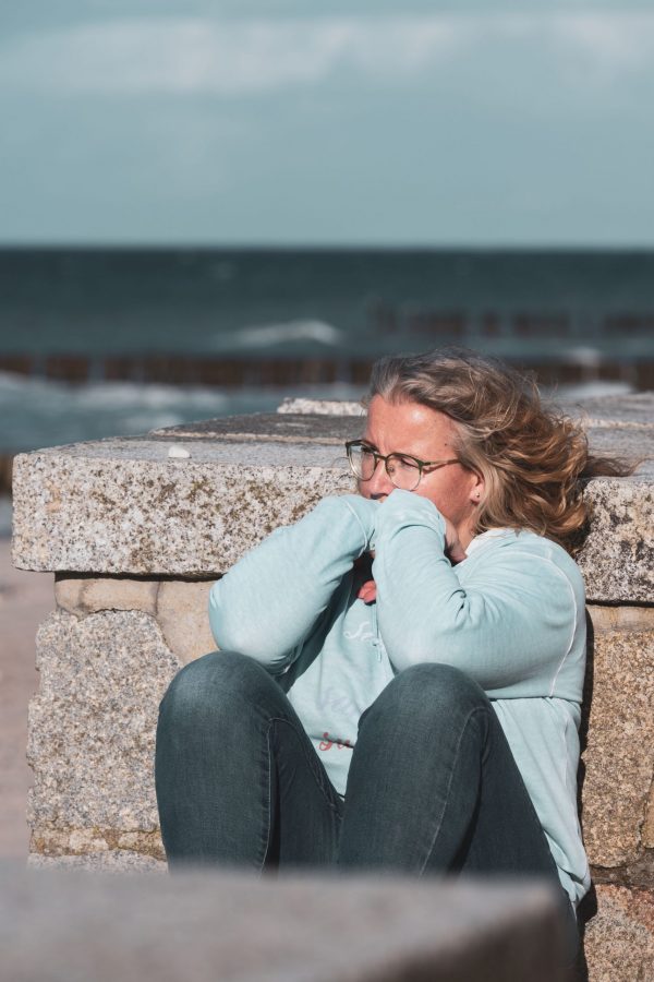 Ostsee, Strand, Wasser, Meer, Jeans, Brille, lange blonde Haar, Sweatshirt, Frauenporträt, Seinmauer