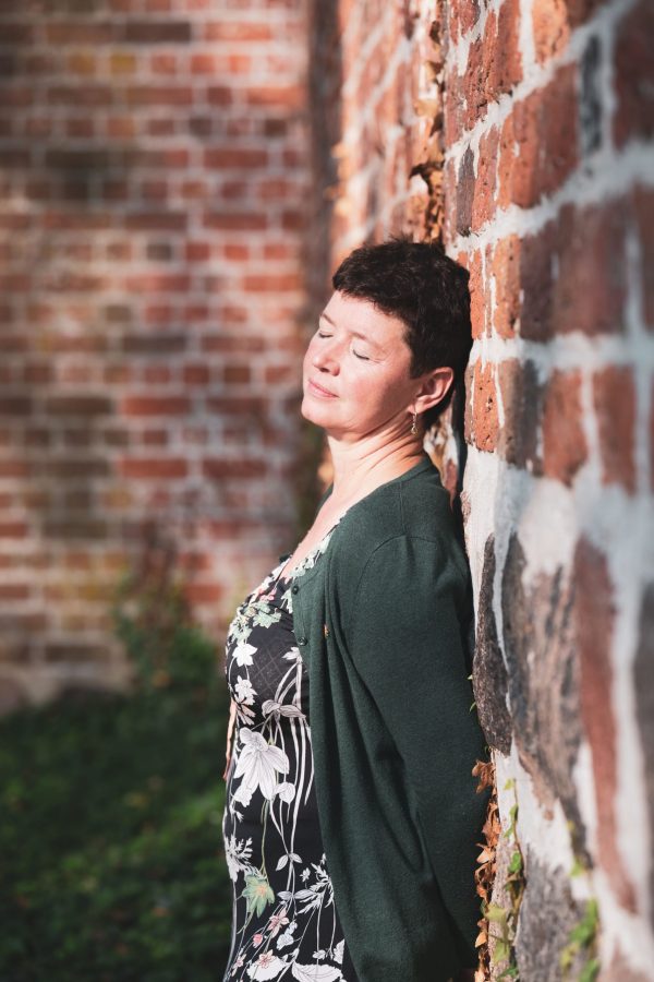 Krummin, Usedom, Insel, Kirche, Backsteingebäude, Sonne, grüne Jacke, Frauenporträt, Blumenkleid,